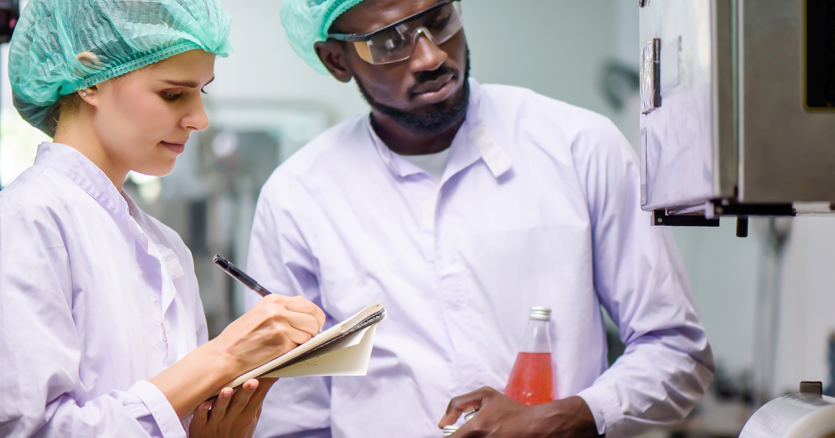 Two food industry professionals stand side by side, inspecting product.