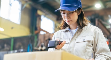 Worker scanning barcode on food package for traceability and inventory tracking in a warehouse environment